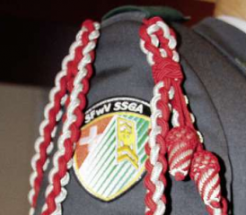 Adj Uof Karl Hanimann zeigt, wie der Fähnrich seine Schnur richtig anbringt: «Die eine Schnur wird unter dem Arm getragen, die andere darüber.»