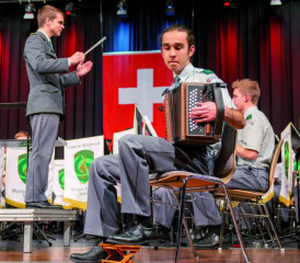 Schlz Marvin Näpflin bei seinem Schwyzerörgeli-Solo. Im Hintergrund dirigiert Lt Mathieu Gili.