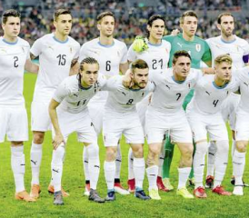 Uruguays kampfstarke Fussball-Elf, als Auswärtsteam nicht im gewohnten Himmelblau, sondern in Weiss, doch mit himmelblauem Kragen. Vorne rechts mit der Nummer 9 der «Beisser» Luis Suarez vom FC Barcelona.