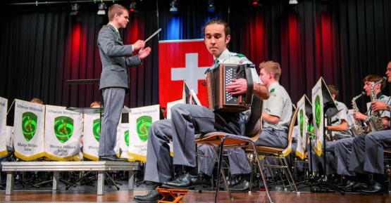 Schlz Marvin Näpflin bei seinem Schwyzerörgeli-Solo. Im Hintergrund dirigiert Lt Mathieu Gili.