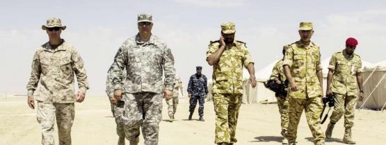 Die USA stationieren in Katar rund 8000 Mann. Generalmajor Robert Catalanotti (im grauen Kampfanzug) inspiziert das Lager Combat Logistics Battalion 26, 26th Marine Expeditionary Unit. Rechts katarische Offiziere in ihrem Wüstenkampftenu.